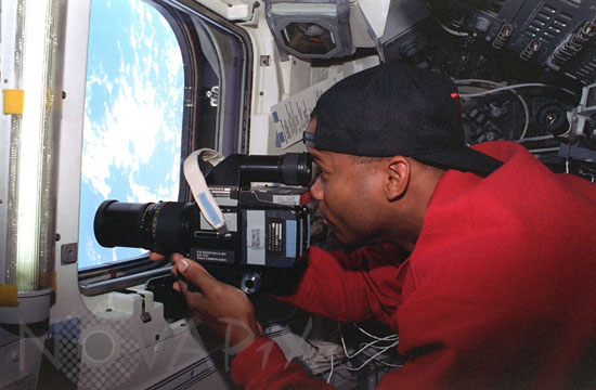 Astronaut Robert Curbeam takes pictures of Earth