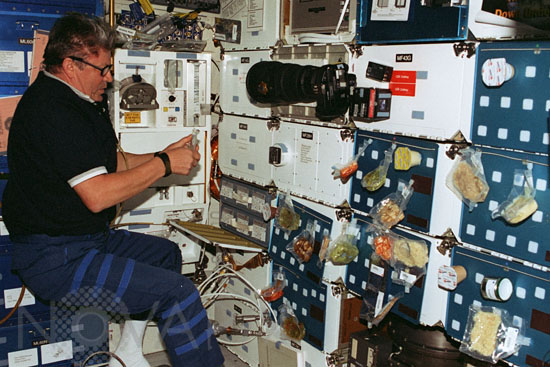 V. Ryumin organizes a meal in the space shuttle. 06/1998